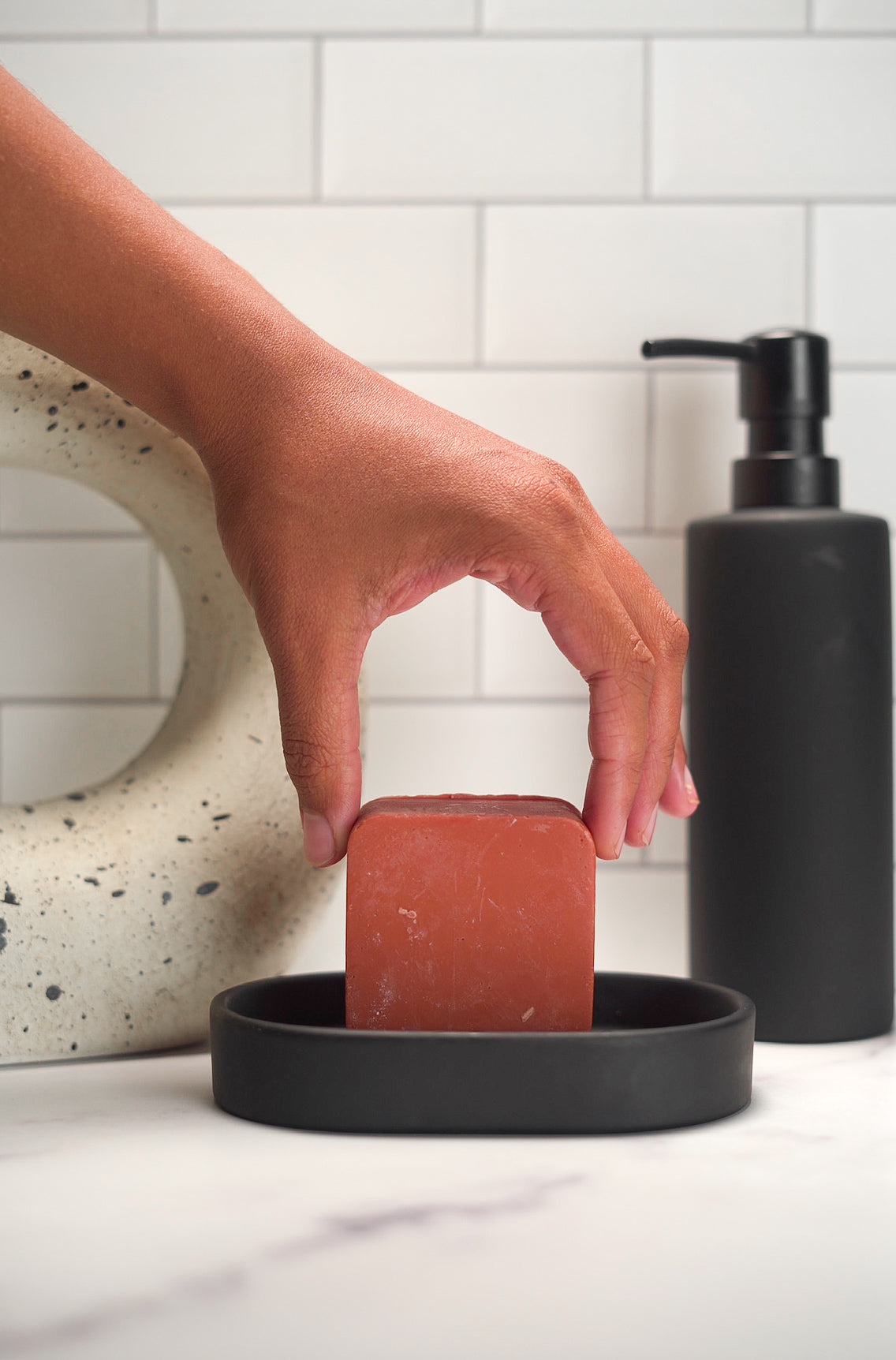 Coconut-Free Red Clay Soap Bar on ceramic dish in minimalist bathroom